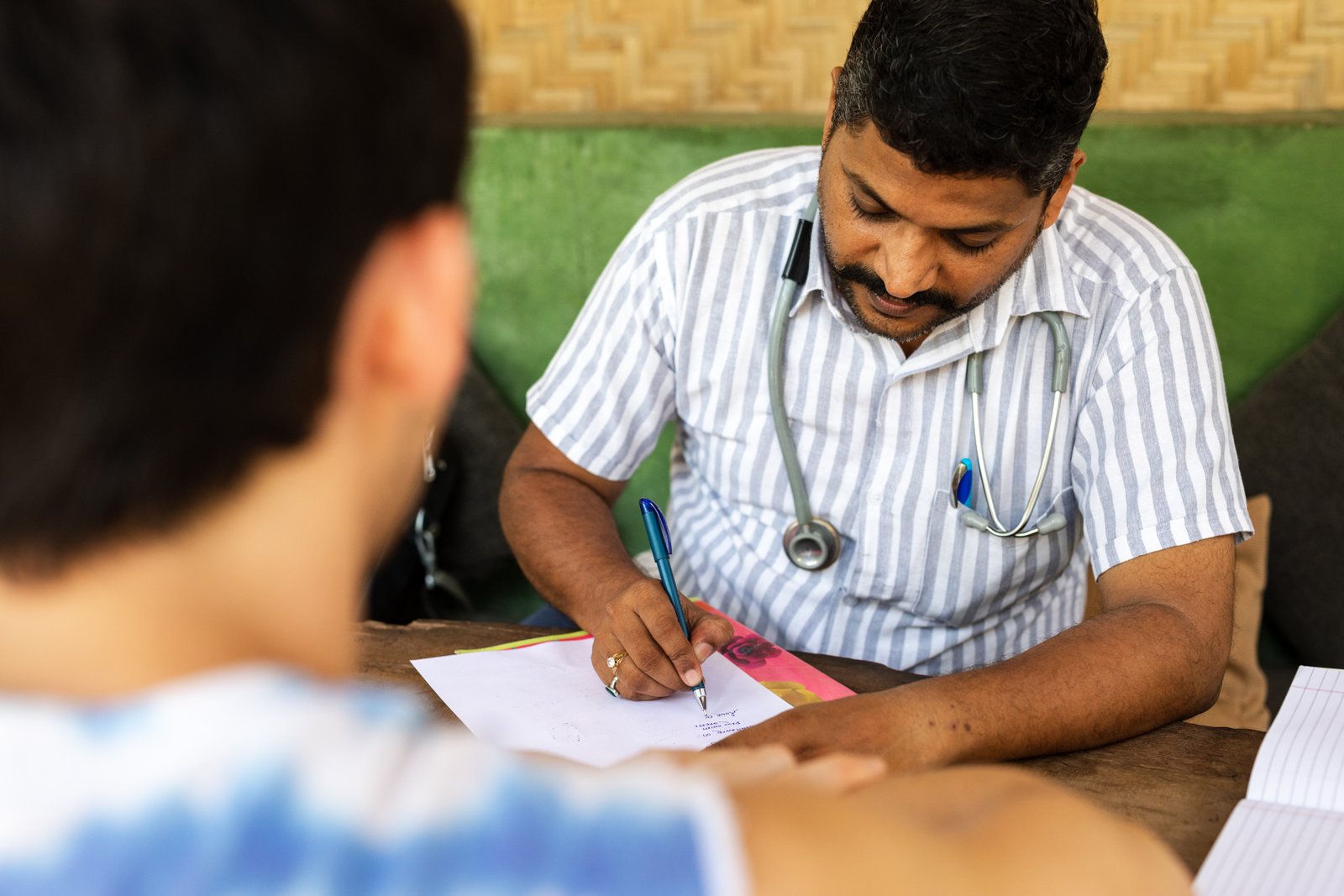 An Ayurvedic doctor at SWAN writing up a day consultation