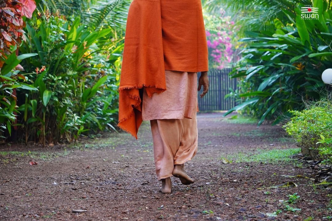 A guest walking the garden path at SWAN Ayurveda Yoga Retreat, Goa